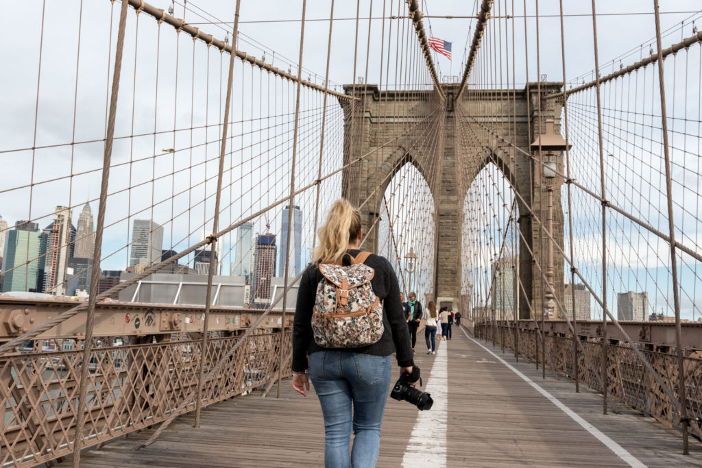 femme avec sac à dos et appareil photo sur brooklyn bridge