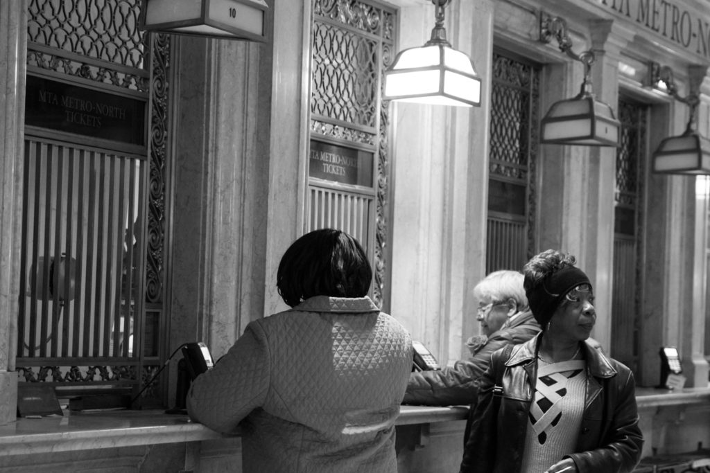 femme au guichet à grand central à new york prenant un billet